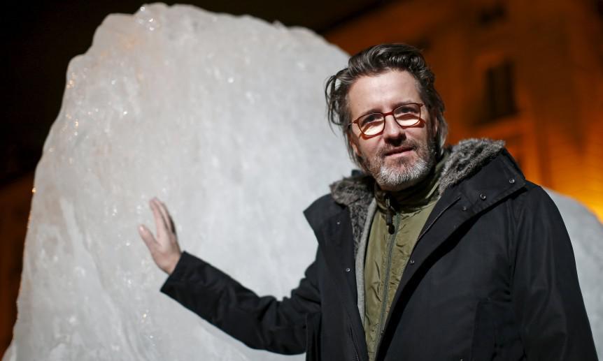 Olafur Eliasson, a Danish-Icelandic artist, poses behind a block of ice that was havested in Greenland and transported in a refrigerated container for a project called Ice Watch Paris, in Paris, France, December 3, 2015. REUTERS/Benoit Tessier