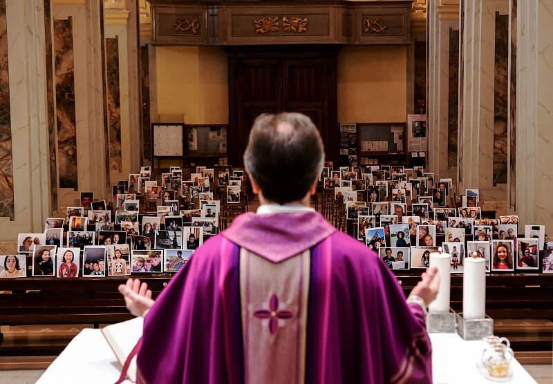 22 Μαρτίου: Ο Giuseppe Corbari πραγματοποιεί την Κυριακάτικη Λειτουργία μπροστά από φωτογραφίες που έστειλαν τα μέλη της εκκλησίας του στο Giussano της Ιταλίας.