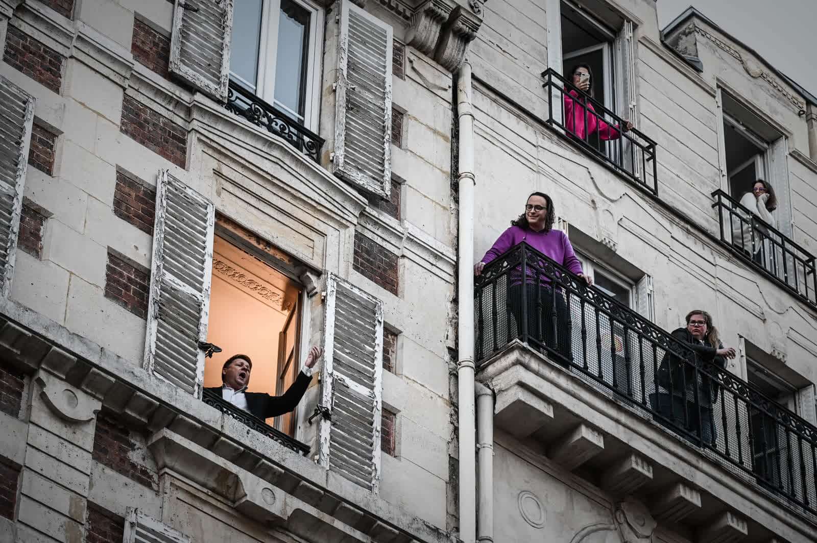 26 Μαρτίου: Ο τραγουδιστής της Όπερας Stephane Senechal τραγουδά για τους γείτονές του από το παράθυρο του διαμερίσματός του στο Παρίσι. 10η ημέρα αυστηρού lockdown στη Γαλλία.