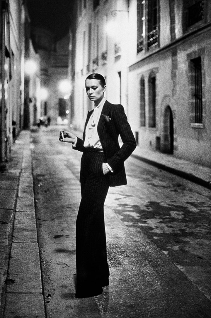 O Helmut Newton γράφει την δική του ιστορία φωτογραφίζοντας το 1975 το ανδρόγυνο LE SMOKING του Yves Saint Laurent, στους δρόμους του Παρισιού. Μία νέα sexy εμφάνιση κατακτά τον κόσμο της μόδας.